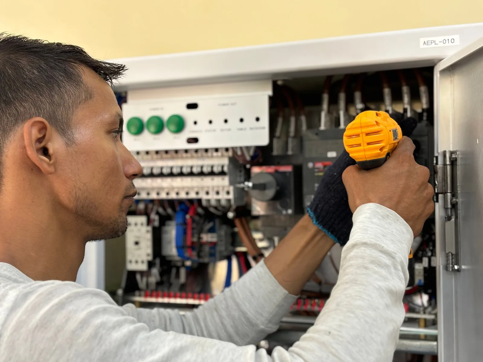 An electrician working on a commercial control panel, for panel upgrade in Buffalo