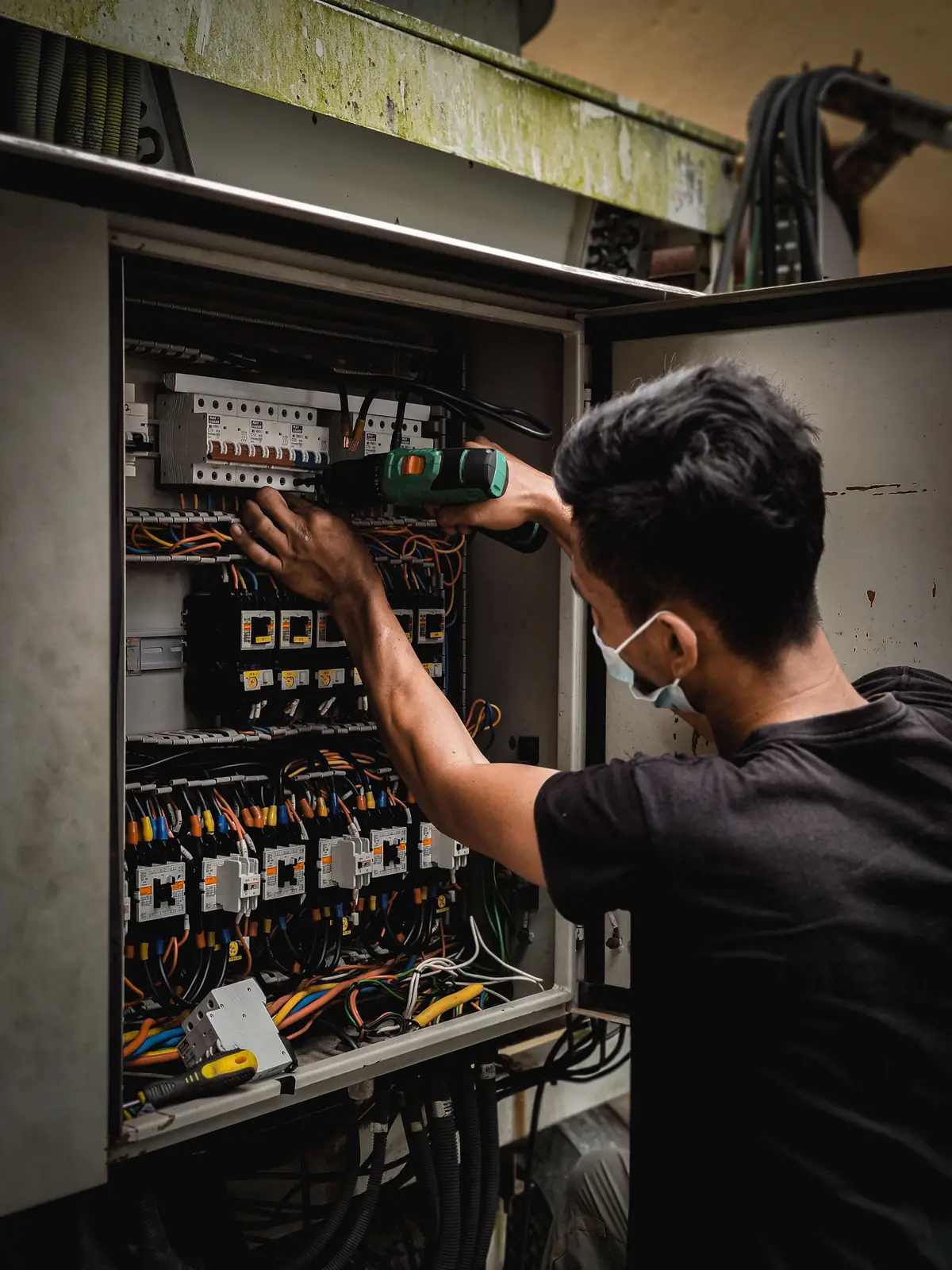 An electrician working inside a large distribution board, for commercial electrical in Buffalo
